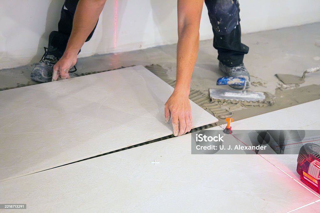 Tiler lays new floor tiles